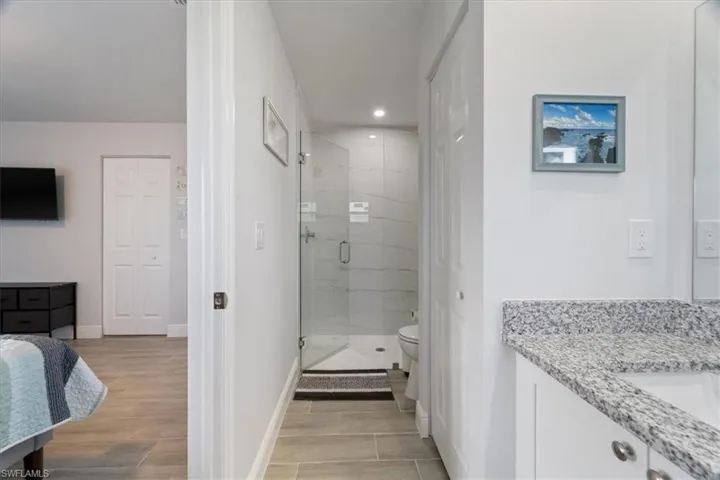 Full bath featuring vanity, a shower stall, recessed lighting, and wood finish floors