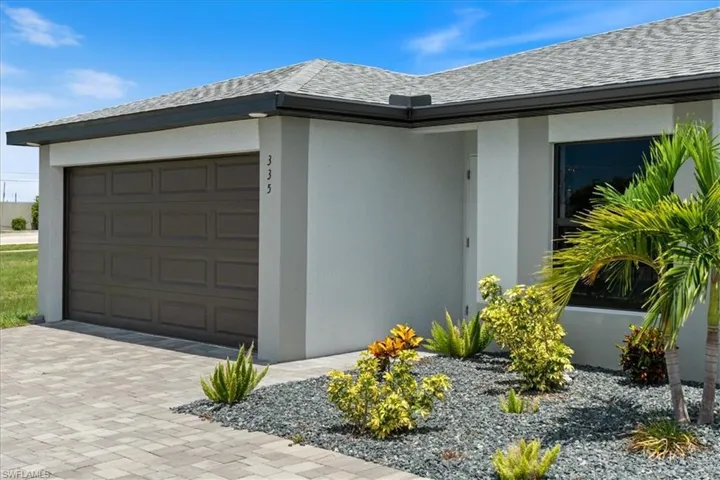 View of property exterior with stucco siding, a garage, driveway, and roof with shingles