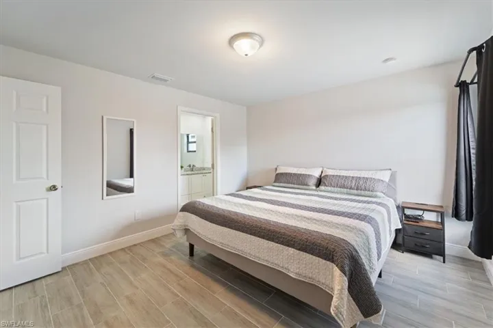 Bedroom with wood finish floors and ensuite bath