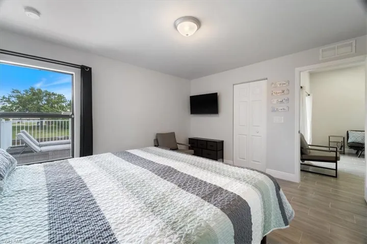 Bedroom featuring wood finish floors, access to exterior, and a closet