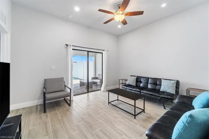 Living area with wood tiled floors, recessed lighting, and a ceiling fan