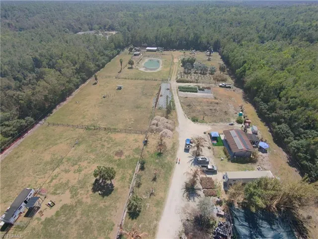 Aerial view of property's location with rural landscape and a forest