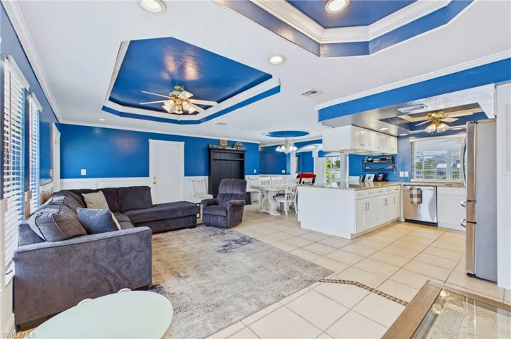 The spacious living room offers the perfect gathering space, featuring abundant natural light, relaxing waterfront views, and easy access to the lanai and pool area.