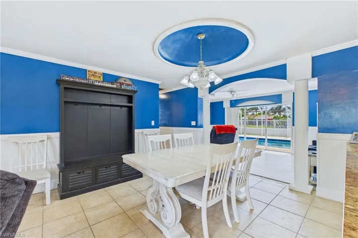 Gather with family and friends in a dining space framed by natural light and waterfront views.