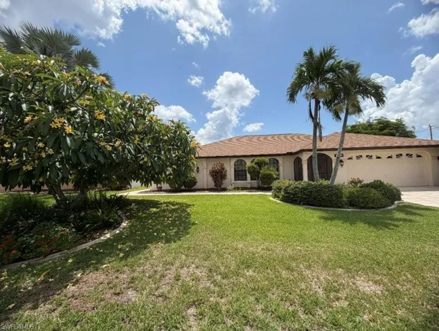 Ranch-style residence featuring a stucco exterior, a tiled roof, and an attached two-car garage