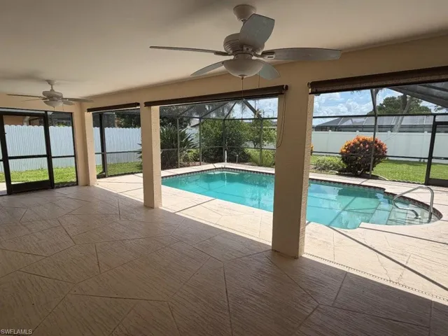 Screened lanai featuring a swimming pool, integrated spa, and expansive patio with ceiling fans