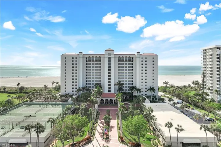 View of building exterior featuring a beach view and a water view