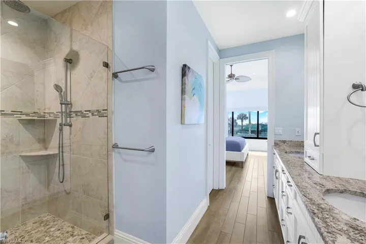 Bathroom featuring wood-type flooring, vanity, and an enclosed shower
