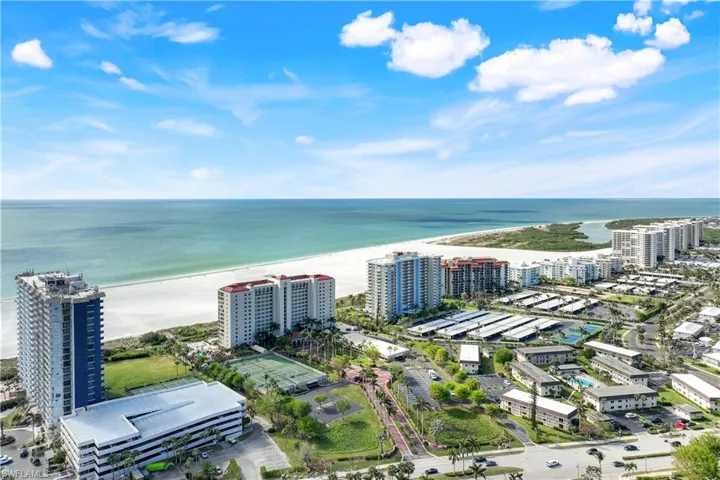 Birds eye view of property featuring a beach view and a water view