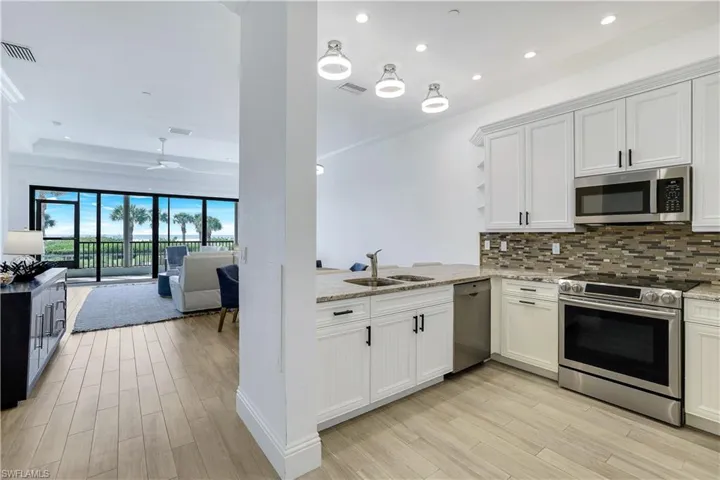 Kitchen featuring light hardwood / wood-style floors, sink, appliances with stainless steel finishes, ceiling fan, and white cabinets