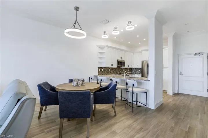 Dining room featuring ornamental molding, light wood-type flooring, and sink