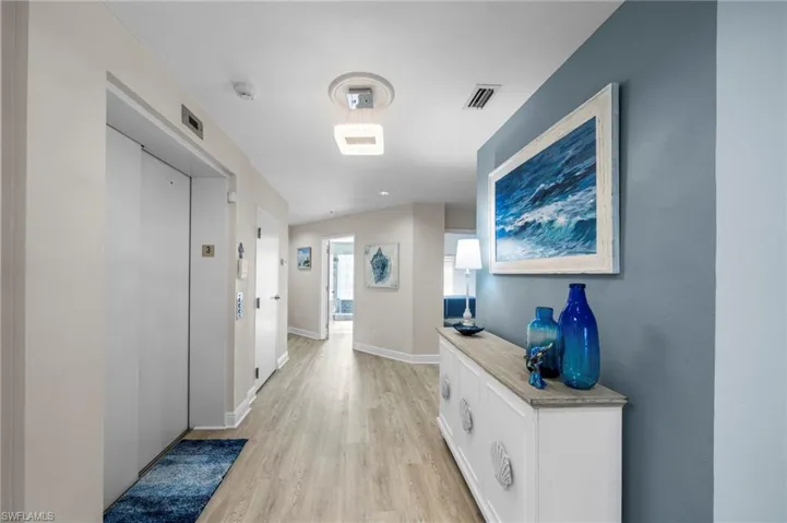 Hall featuring elevator and light wood-style floors