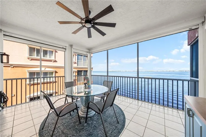 Sunroom / solarium featuring a water view and a ceiling fan