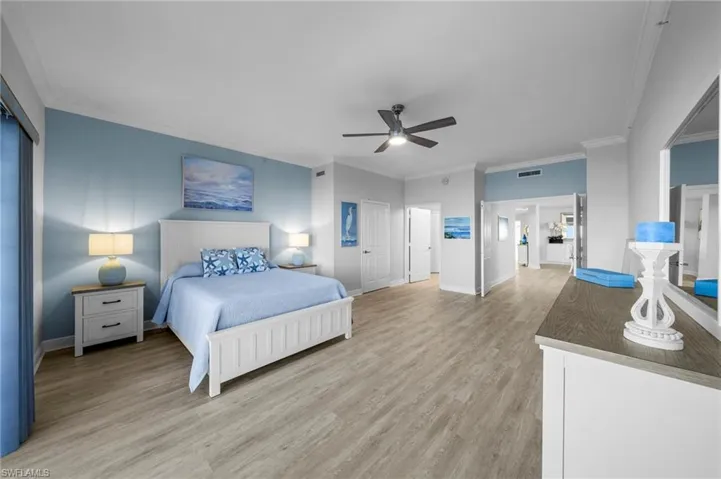 Bedroom featuring light wood-style flooring, ornamental molding, a closet, and ceiling fan