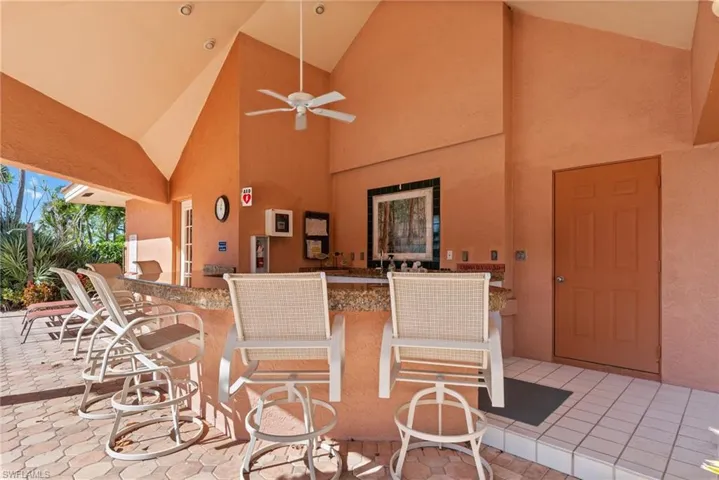 View of patio with a ceiling fan and a bar