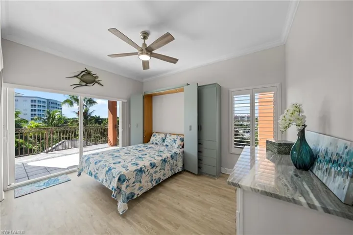 Bedroom featuring crown molding, access to exterior, light wood-type flooring, and a ceiling fan