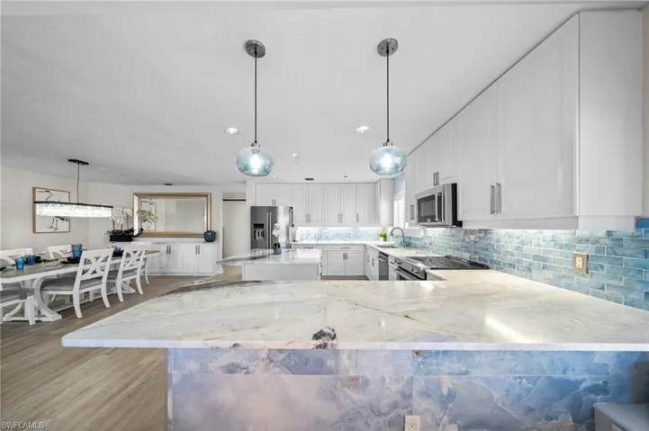Kitchen featuring tasteful backsplash, white cabinets, pendant lighting, appliances with stainless steel finishes, and recessed lighting