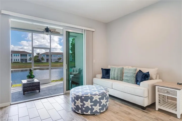 Living area with tile floors, a ceiling fan, and a water view