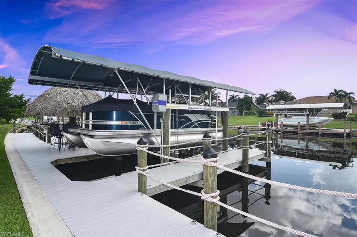 Dock featuring boat lift and a water view