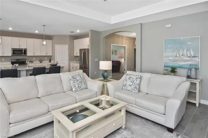 Kitchen featuring stainless steel appliances, a kitchen breakfast bar, white cabinetry, and recessed lighting