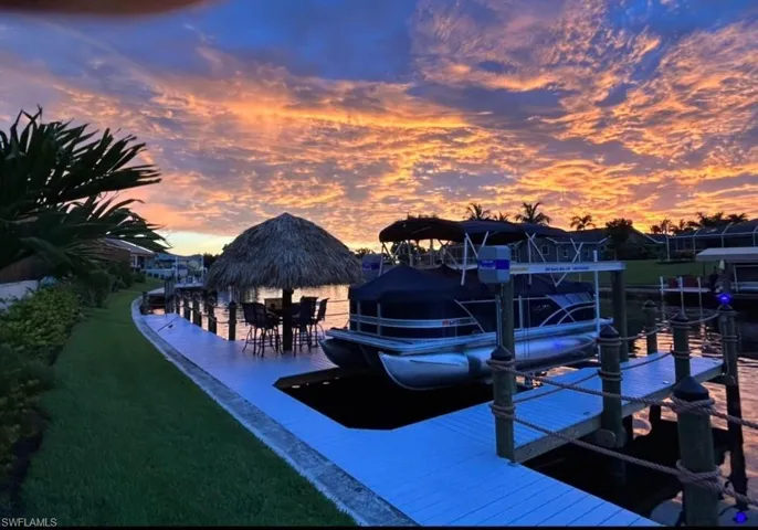 View of pool featuring a pool with connected hot tub, a lanai, a water view, and a patio area