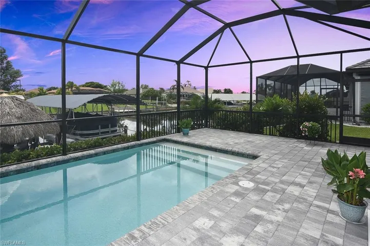 Swimming pool with a patio area, a lanai, and a water view