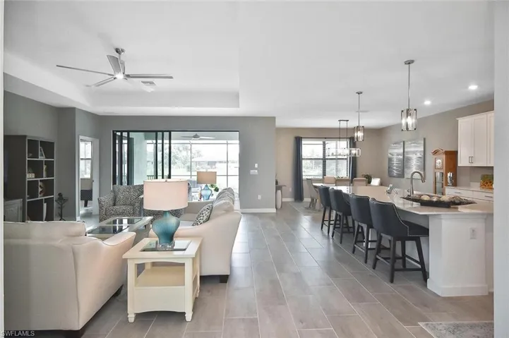 Kitchen with stainless steel appliances, white cabinetry, decorative light fixtures, and recessed lighting