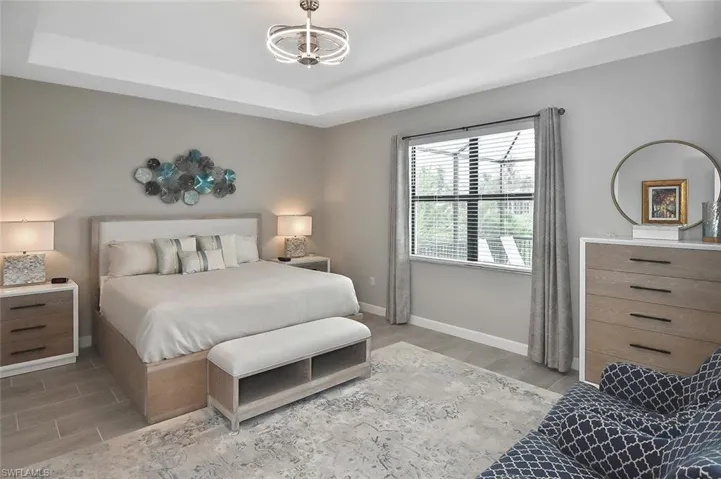 Bedroom with a tray ceiling and wood finish floors