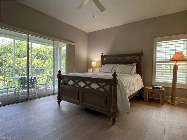 Bedroom with ceiling fan, access to exterior, and hardwood / wood-style flooring