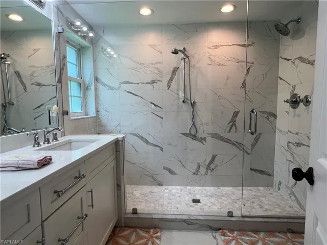 Bathroom with tile patterned flooring, vanity, and walk in shower