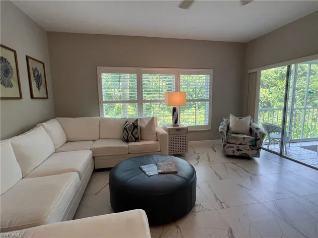 Living room with light tile patterned floors and a wealth of natural light