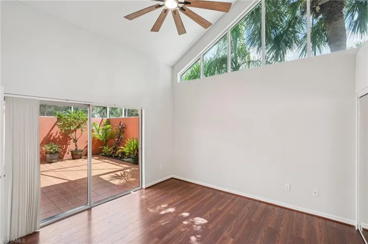 Spare room featuring high vaulted ceiling, wood finished floors, and ceiling fan