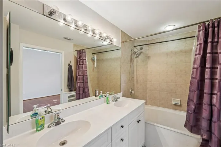 Full bathroom with shower / bath combo and double vanity