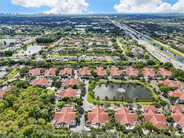 Aerial view of property and surrounding area featuring a nearby body of water and nearby suburban area
