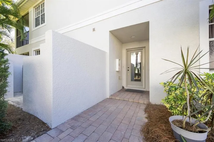 Doorway to property featuring stucco siding