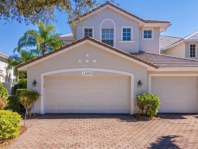 View of front of house with a tiled roof, decorative driveway, and stucco siding