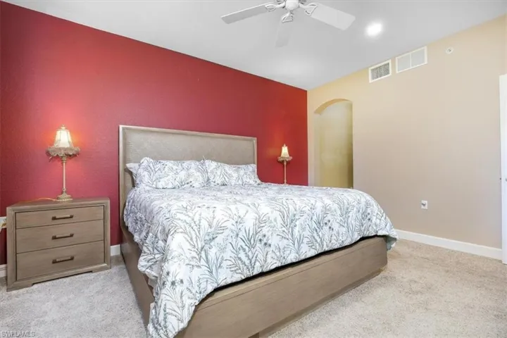 Bedroom with a ceiling fan and light colored carpet