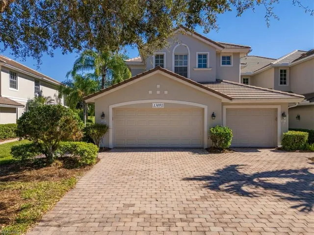 View of front of home featuring decorative driveway, stucco siding, a tile roof, and an attached garage