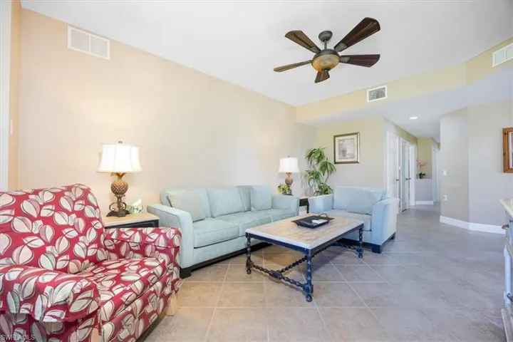 Living area with a ceiling fan and light tile patterned floors