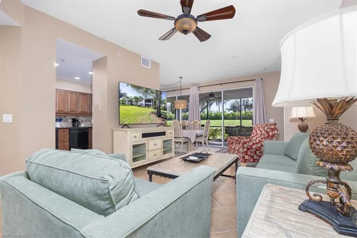 Living room with ceiling fan, light tile patterned floors, and recessed lighting