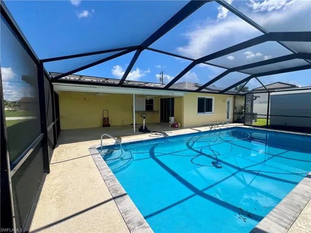 Swimming pool featuring a sunroom, a lanai, a patio area, and ceiling fan