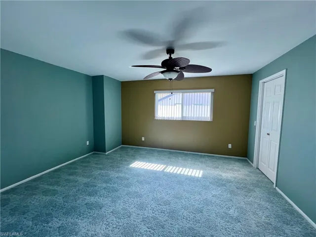 Unfurnished bedroom featuring ceiling fan and carpet