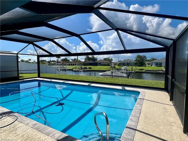 Swimming pool featuring a sunroom, a water view, a lanai, a dock, and a residential view