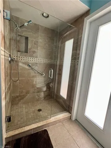 Bathroom with a shower stall and tile patterned floors