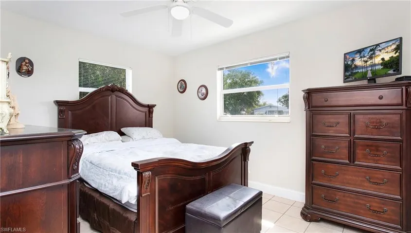 Bedroom featuring light tile patterned flooring, baseboards, and ceiling fan
