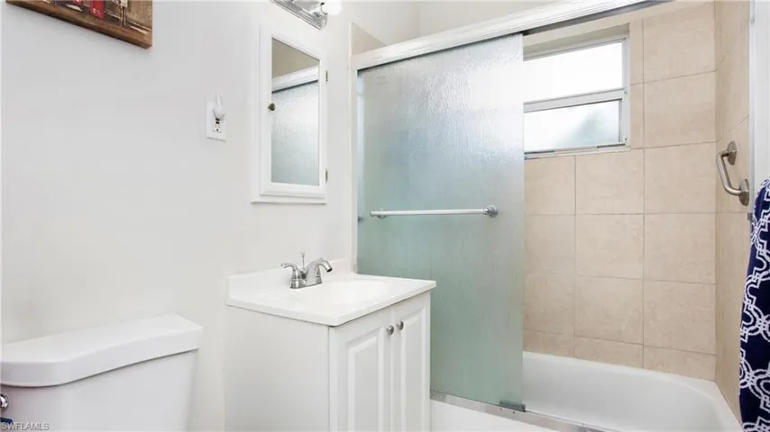Full bath with vanity, shower / tub combo with curtain, and toilet