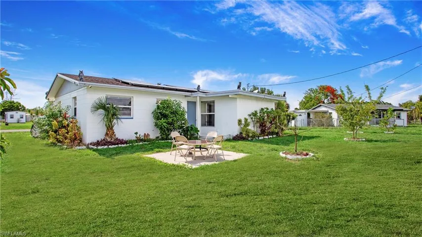 Back of property with a patio area and roof mounted solar panels