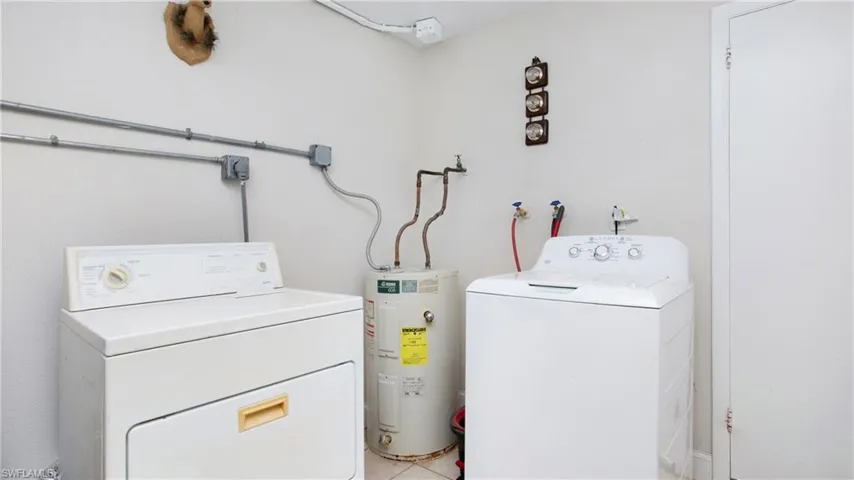 Laundry area featuring water heater and washer and clothes dryer