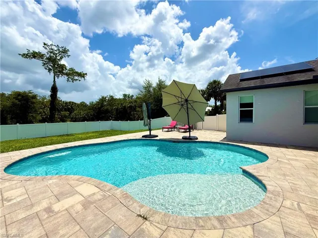 View of swimming pool with a patio and a fenced backyard