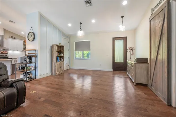 Living area with baseboards, dark wood-style floors, visible vents, and recessed lighting